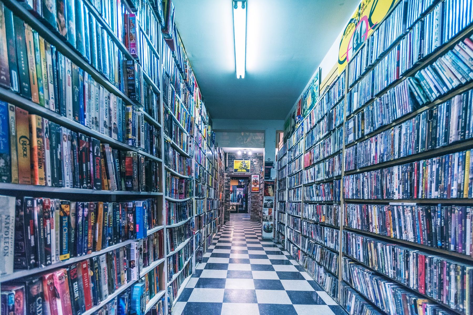 A video store aisle lined floor to ceiling with movie cases
